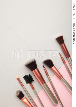 Various makeup brushes on grey and pink background with copy space. Vertical photo Various makeup brushes on grey and pink background with copy space. Vertical photo 119293768