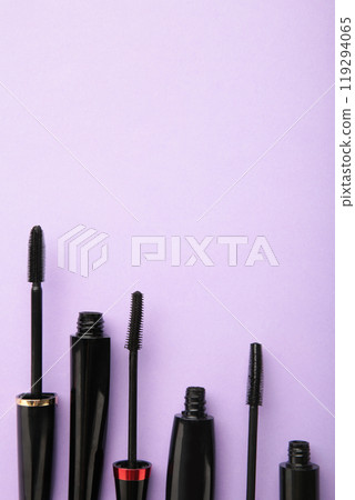 Black mascara wand and tube on purple background with copy space. Vertical photo Black mascara wand and tube on purple background with copy space. Vertical photo 119294065