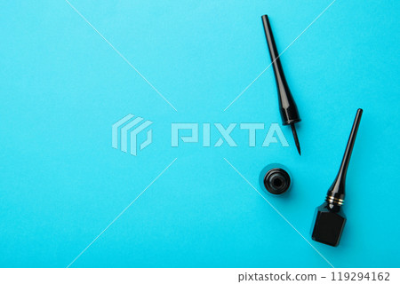 Eyeliners on blue background with copy space. Top view Eyeliners on blue background with copy space. Top view 119294162