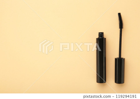 Black mascara wand and tube on beige background with copy space Black mascara wand and tube on beige background with copy space 119294191