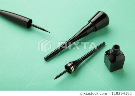 Eyeliners on mint background with copy space. Top view 119294193