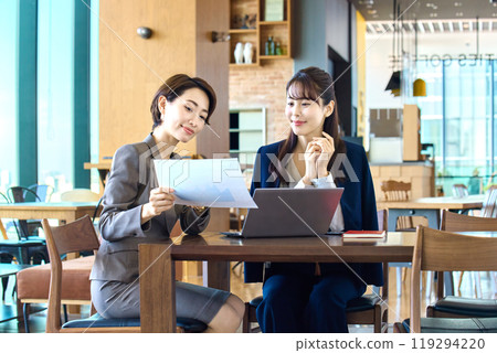 Two businesswomen having a meeting while using a computer in a cafe (casual) Two businesswomen having a meeting while using a computer in a cafe (casual) 119294220