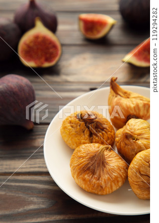 Group of dried figs in a bowl on brown background. 119294282