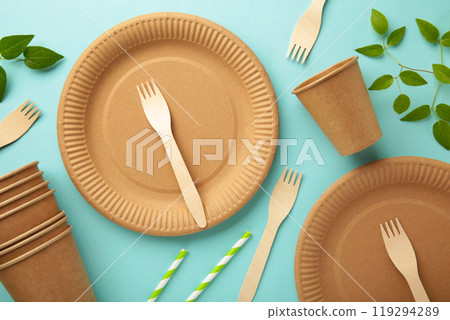 Eco friendly disposable dishes with green leaves on blue background. Zero waste, eco friendly, plastic free background. Eco friendly disposable dishes with green leaves on blue background. Zero waste, eco friendly, plastic free background. 119294289