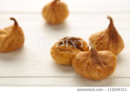 Group of dried figs on white wooden background. 119294321