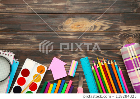 School supplies on brown wooden background with copy space. Back to school concept. School supplies on brown wooden background with copy space. Back to school concept. 119294323