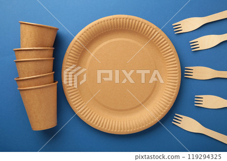 Eco craft paper tableware. Paper cups, dishes, bag, fast food containers and wooden cutlery on dark blue background. Zero waste. Recycling concept. Copy space 119294325