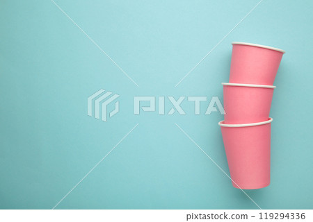 Disposable pink paper cups on blue background. Top view. 119294336