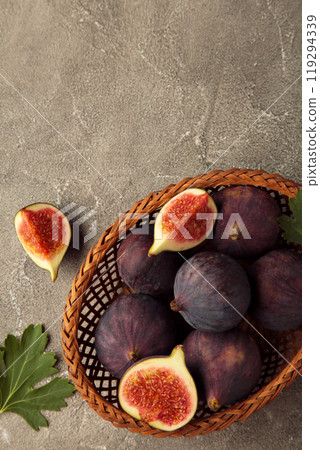 Group of figs in a wooden bowl on blue background. Group of figs in a wooden bowl on blue background. 119294339
