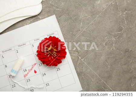 Menstruation calendar with cotton tampons and pads on grey background. Woman critical days, woman hygiene protection. Menstrual pain Menstruation calendar with cotton tampons and pads on grey background. Woman critical days, woman hygiene protection. Menstrual pain 119294355