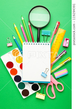 Notebook with stationary objects on green background Notebook with stationary objects on green background 119294391