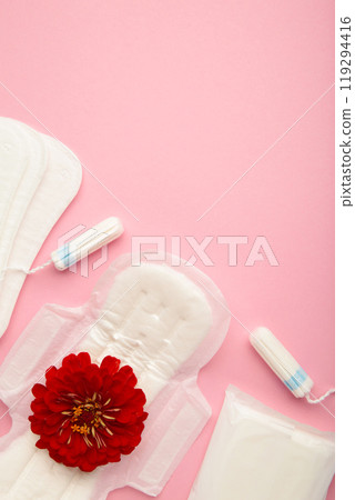 Menstrual tampons and pads on a pink background. Menstruation cycle. Hygiene and protection. A rose flower lies on a menstrual pad. Menstrual tampons and pads on a pink background. Menstruation cycle. Hygiene and protection. A rose flower lies on a menstrual pad. 119294416