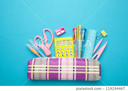Pencil case and school supplies on blue background. Back to school concept. Pencil case and school supplies on blue background. Back to school concept. 119294467