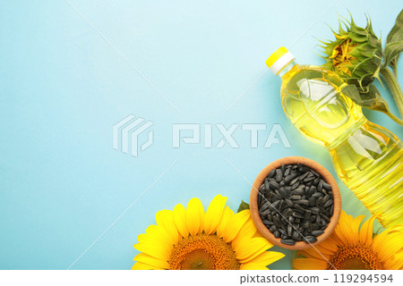 Sunflower seeds and bottle of oil on blue background. 119294594