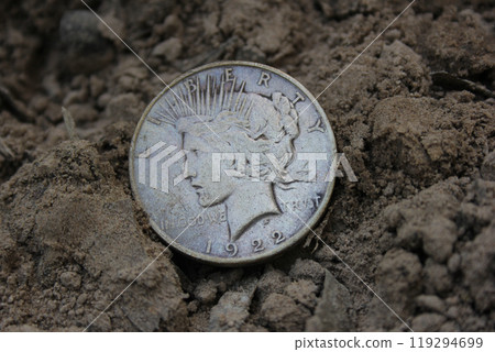 1922 Silver Peace Dollar On Ground in Dirt. Front View 1922 Silver Peace Dollar On Ground in Dirt. Front View 119294699