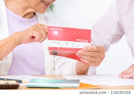 Parent and child end of life planning: mother, son, bankbook in hand 119295108