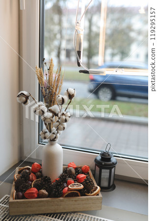 autumn cozy still life.pumpkins, lantern, autumn leaves by window. fall season, thanksgiving and halloween concept. 119295157