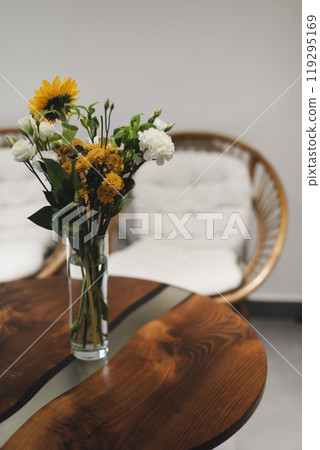 bouquet of beautiful yellow sunflower flowers in a glass vase on an old rustic wooden table. Autumn cozy home decor bouquet of beautiful yellow sunflower flowers in a glass vase on an old rustic wooden table. Autumn cozy home decor 119295169