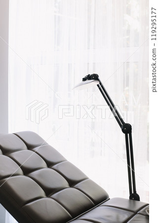equipment in a modern cosmetology clinic. Lamp and comfortable Chair in a beauty salon equipment in a modern cosmetology clinic. Lamp and comfortable Chair in a beauty salon 119295177