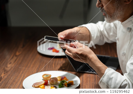 Chef taking a photo of the food Chef taking a photo of the food 119295462