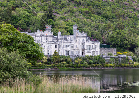 Kylemore Abbey in Connemara with neo-Gothic architecture by the lake, framed by greenery and flowers 119296062