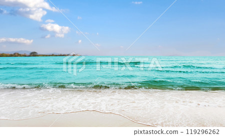 Stunning view of azure ocean waves gently crashing onto a pristine sandy beach, evoking a sense of relaxation and escape. The image conveys the idea of a perfect vacation by the sea. 119296262
