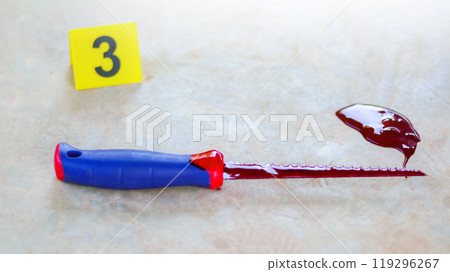 A bloodstained stainless steel handsaw lying on a concrete floor, with a blurred yellow marker number 3 and scattered blood drops, symbolizing a violent crime scene under investigation. A bloodstained stainless steel handsaw lying on a concrete floor, with a blurred yellow marker number 3 and scattered blood drops, symbolizing a violent crime scene under investigation. 119296267