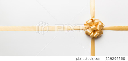 Top view of gold ribbon rolled and yellowbow isolated on colored background. Flat lay with copy space Top view of gold ribbon rolled and yellowbow isolated on colored background. Flat lay with copy space 119296568