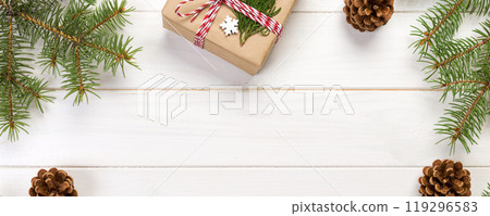 Christmas background with fir tree and gift box on wooden table. Top view with copy space for your design Christmas background with fir tree and gift box on wooden table. Top view with copy space for your design 119296583