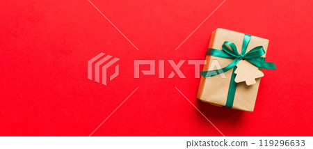 wrapped christmas or other holiday handmade present in paper with colored ribbon. Present box, decoration of gift on colourfull table, top view with copy space wrapped christmas or other holiday handmade present in paper with colored ribbon. Present box, decoration of gift on colourfull table, top view with copy space 119296633