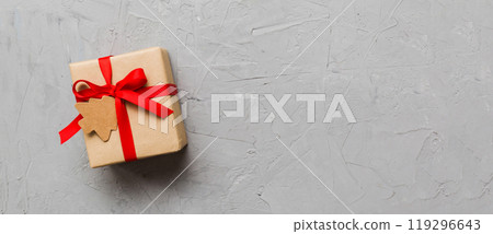 wrapped christmas or other holiday handmade present in paper with colored ribbon. Present box, decoration of gift on colourfull table, top view with copy space 119296643