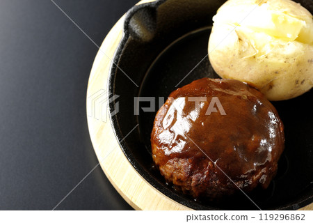 Hamburg steak and buttered potatoes photographed against a black background Hamburg steak and buttered potatoes photographed against a black background 119296862