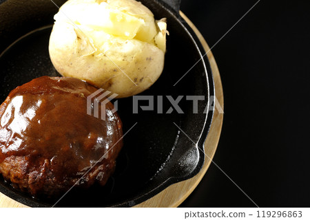 Hamburg steak and buttered potatoes photographed against a black background Hamburg steak and buttered potatoes photographed against a black background 119296863