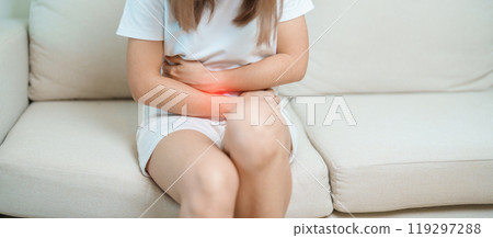 woman having abdomen ache due to Stomach pain, digestion with constipation or Diarrhea from food poisoning, female problem and Endometriosis, Hysterectomy, Stomachache and Menstrual on sofa at home 119297288