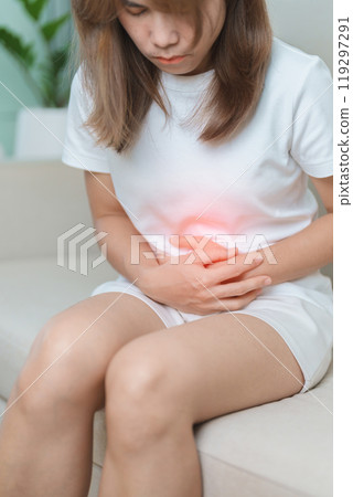 woman having abdomen ache due to Stomach pain, digestion with constipation or Diarrhea from food poisoning, female problem and Endometriosis, Hysterectomy, Stomachache and Menstrual on sofa at home 119297291