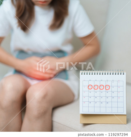 Menstruation period cycle of monthly and Stomachache concepts. woman having abdomen pain with hot water bottle and calendar, illness female suffer from premenstrual ache and body Health problem 119297294