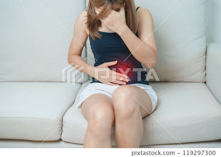 woman having abdomen ache due to Stomach pain, digestion with constipation or Diarrhea from food poisoning, female problem and Endometriosis, Hysterectomy, Stomachache and Menstrual on sofa at home 119297300