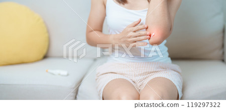 Arthritis and Muscle Pain Relief Cream concept. Woman having elbow ache at home, muscle pain due to lateral epicondylitis or tennis elbow. injury, Health and medical concept 119297322