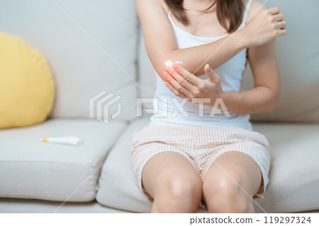 Arthritis and Muscle Pain Relief Cream concept. Woman having elbow ache at home, muscle pain due to lateral epicondylitis or tennis elbow. injury, Health and medical concept 119297324