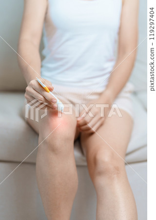 Arthritis and Muscle Pain Relief Cream concept. woman having knee ache and muscle pain due to Runners Knee or Patellofemoral Pain Syndrome, osteoarthritis, rheumatism and Patellar Tendinitis 119297404