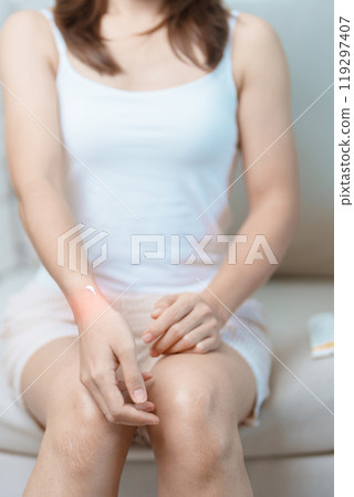 Arthritis and Muscle Pain Relief Cream concept. Woman having wrist pain at home, muscle ache due to De Quervain s tenosynovitis, ergonomic, Carpal Tunnel Syndrome or Office syndrome and Parkinson 119297407