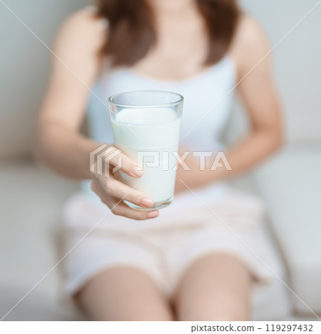 Lactose intolerance and Milk allergy concept. woman hold Milk glass and having abdominal cramps and pain when drink Cow Milk. Symptom stomach ache, Dairy intolerant, Nausea, Bloating, Gas and Diarrhea 119297432