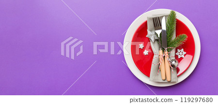 Christmas table place setting with christmas decor and plates, kine, fork and spoon. Christmas holiday background. Top view with copy space Christmas table place setting with christmas decor and plates, kine, fork and spoon. Christmas holiday background. Top view with copy space 119297680