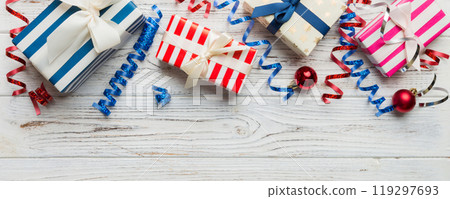 Holiday flat lay with gift boxes wrapped in colorful paper and tied decorated with confetti on colored background. Christmas, Birthday, Valentine and sale concept, top view Holiday flat lay with gift boxes wrapped in colorful paper and tied decorated with confetti on colored background. Christmas, Birthday, Valentine and sale concept, top view 119297693