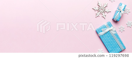 Holiday flat lay with gift boxes wrapped in colorful paper and tied decorated with confetti on colored background. Christmas, Birthday, Valentine and sale concept, top view 119297698