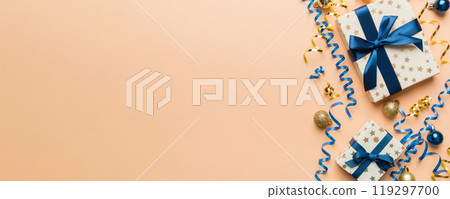 Holiday flat lay with gift boxes wrapped in colorful paper and tied decorated with confetti on colored background. Christmas, Birthday, Valentine and sale concept, top view Holiday flat lay with gift boxes wrapped in colorful paper and tied decorated with confetti on colored background. Christmas, Birthday, Valentine and sale concept, top view 119297700