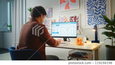 Young man types prompt in AI video generator on personal computer 119298196