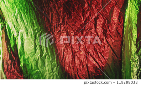 Crumpled foil. Wrinkled texture. Defocused shiny glossy green red color distressed creased polyethylene film abstract background. 119299038
