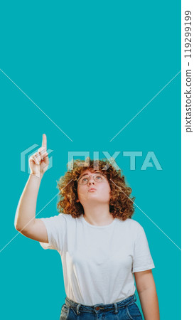 Idea discovery. Surprised curious woman pointing up learning advertising isolated on blue copy space background. 119299199