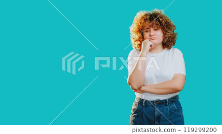 Pensive face. Hard decision. Confused doubtful puzzled girl with curly hair considering options isolated on blue copy space background. 119299200